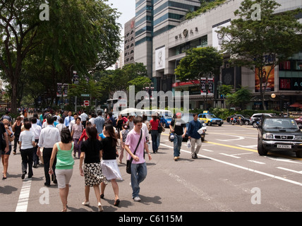 Pedoni che attraversano intersezione di Paterson Road e Orchard Road, Singapore Foto Stock