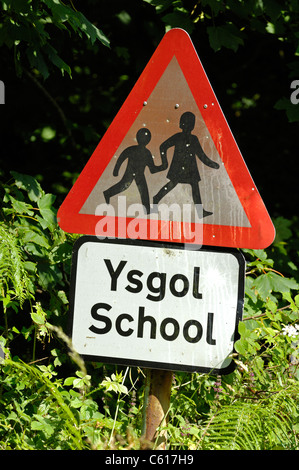 Welsh cartello stradale che indica la scuola o di attraversamento scuola e attenzione dei bambini visualizzati in gallese e inglese. Foto Stock