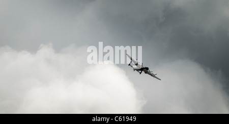 Una seconda guerra mondiale Avro Lancaster bombardiere, parte della Battaglia di Bretagna volo, REGNO UNITO - in volo, grigio nuvole nere Foto Stock