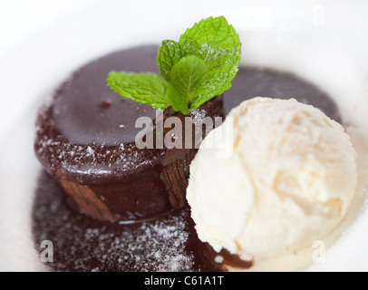Souffle al cioccolato con salsa di cioccolato e gelato alla vaniglia. Foto Stock