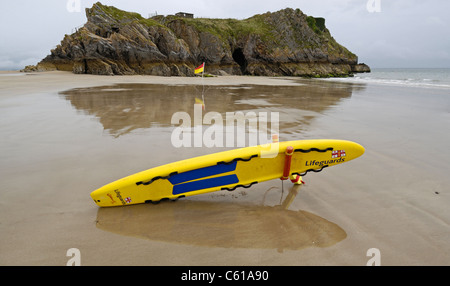 R.N.L.I. Schede di soccorso pronto per essere usato in caso di emergenza sulla spiaggia di Tenby, Galles con l'isola di Santa Caterina e. Foto Stock