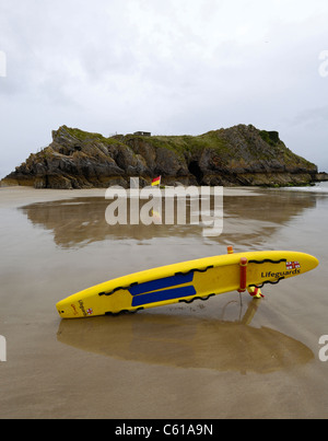 R.N.L.I. Schede di soccorso pronto per essere usato in caso di emergenza sulla spiaggia di Tenby, Galles con l'isola di Santa Caterina e. Foto Stock