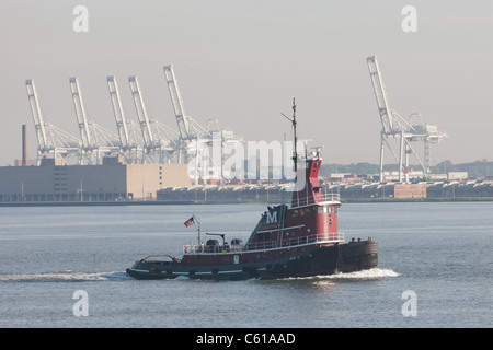 Rimorchiatore 'Jean Turecamo' capi del nord nel porto di New York, con il Global Terminal container gru in background. Foto Stock