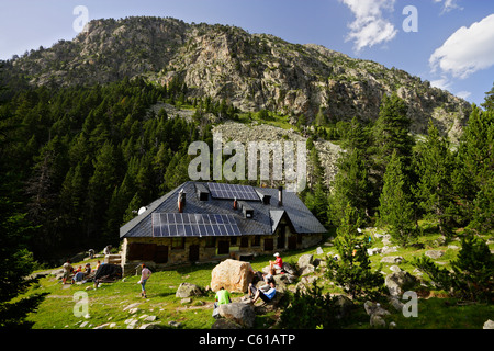 Gli escursionisti in appoggio a Estany Llong baita di montagna, Aigüestortes i Estany de Sant Maurici National Park, Pirenei, Spagna Foto Stock