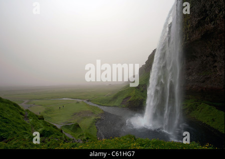 Seljalandsfoss cascata con un sacco di particelle di polvere nell'aria da Eyjafjallajokull eruzione del vulcano a 2010, Islanda Foto Stock
