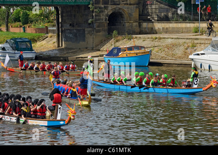 Le persone si preparano a gareggiare nella sfida Dragon Boat Per beneficenza in estate sul fiume Ouse York North Yorkshire Inghilterra Regno Unito Foto Stock