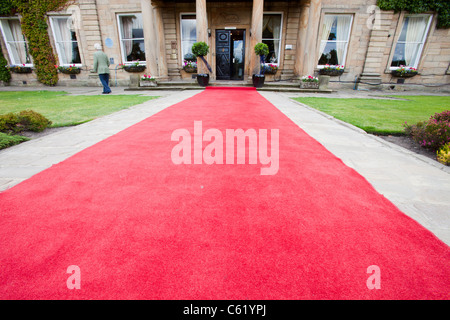 Un tappeto rosso che conduce verso Walton Hall vicino a Wakefield, Yorkshire, Regno Unito. Foto Stock