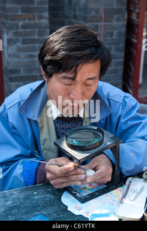 Artigiano lavora con Jade in Guwenhua Jie antica cultura Street, Tianjin, Cina Foto Stock