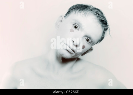 Giovane uomo con il trucco bianco e rosso cuori invece delle lacrime Foto Stock