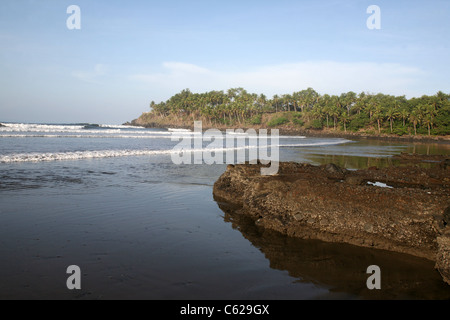 Spiaggia di sabbia nera e ciottoli punto a Las Flores, El Salvador. Foto Stock