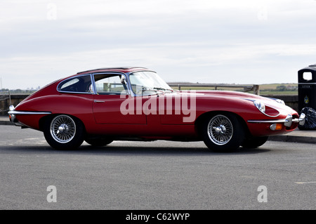 Il profilo laterale di ROSSO E-type Jaguar nel cinquantesimo anniversario sul parcheggio auto Foto Stock