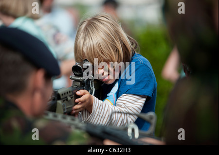 Un ragazzo in possesso di un fucile a un esercito stand fieristico. Eastbourne, East Sussex. Inghilterra, Regno Unito Foto Stock