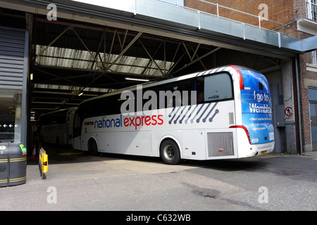 La National Express Coach, riconoscibile livrea della capillare servizio di bus, un allenatore ritorna alla stazione degli Autobus Victoria di Londra. Foto Stock