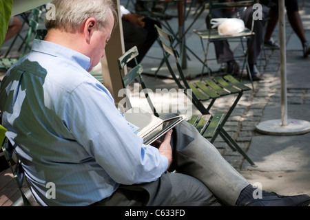 Un lettore utilizza il suo Amazon Kindle ereader in Bryant Park di New York venerdì, 12 agosto 2011. (© Richard B. Levine) Foto Stock