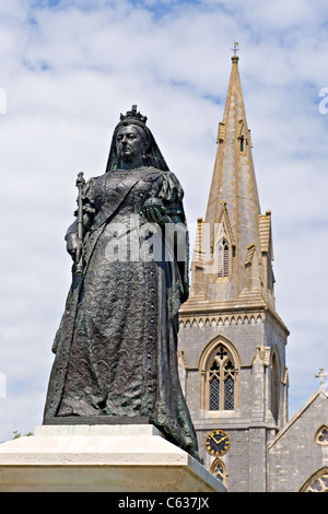 La regina Victoria statua, Greenhill, Weymouth Dorset, England, Regno Unito con la Chiesa di San Giovanni Evangelista in background Foto Stock