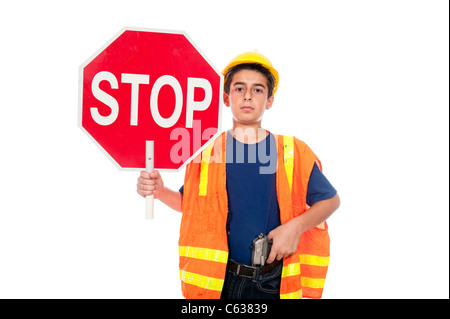 Un ragazzo dirige il traffico utilizzando un segnale di stop e una pistola Foto Stock