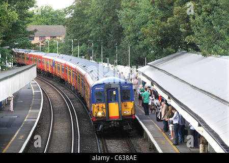 Pendolari di salire a bordo del treno di mattina a Mortlake, Londra Foto Stock
