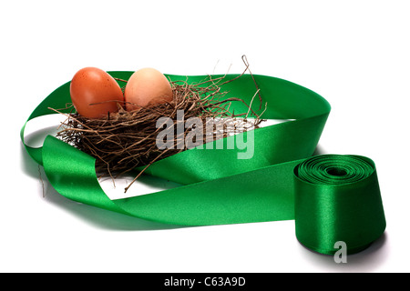 Simgera di uova in nidi e nastri verdi Foto Stock