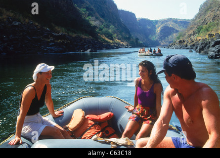 Turisti e guide rilassante mentre il rafting sul fiume Zambesi tra rapide e tra Zambia e Zimbabwe Foto Stock