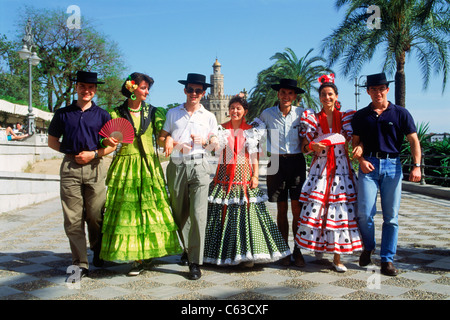 Giovani uomini e donne con i tradizionali costumi colorati durante "Feria de Sevilla' festival di Siviglia (Sevilla), Spagna Foto Stock