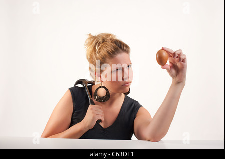 Pianificazione bionda alcuni male con un uovo Foto Stock