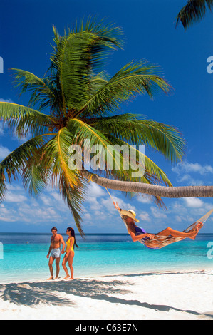 Giovane donna che passa in amaca sulla isola di Fihalhohi delle Maldive Foto Stock
