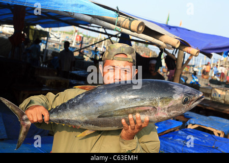 Uomo con un tonno al lato della porta di mercato del pesce Foto Stock