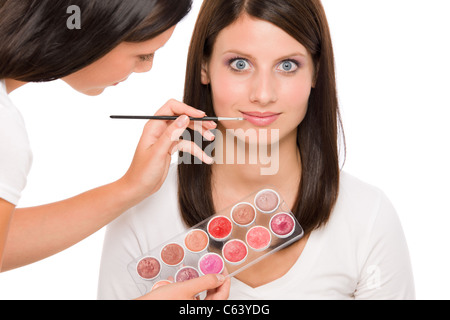 Make-up artist donna modello di moda applicare il rossetto dalla tavolozza dei colori Foto Stock