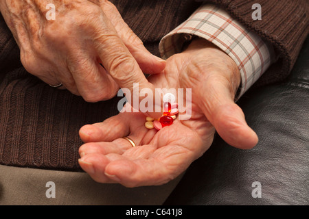 Un uomo anziano ordina pillole in mano Foto Stock