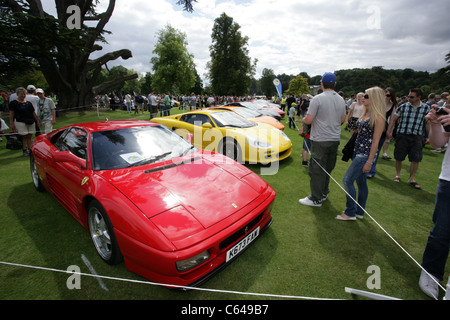 Un rosso ferrari tra le altre vetture a classic car show a Wilton House, Wiltshire. Foto Stock