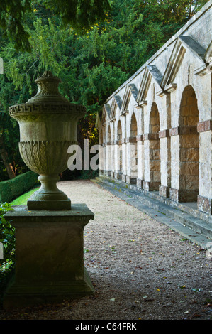 Le sette Arcade ad arco da William Kent accanto a un riccamente intagliato in pietra urna classica a Rousham House, Oxfordshire, Inghilterra Foto Stock