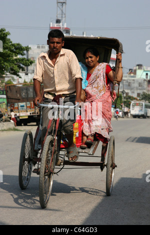 Il nepalese di triciclo rickshaw con la donna passeggero al Sanauli sull'India confine nepalese Foto Stock