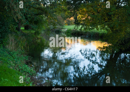 Autunno colori riflessi nel fiume Cherwell che costituisce il confine per motivi di Rousham House in Oxfordshire, Inghilterra Foto Stock