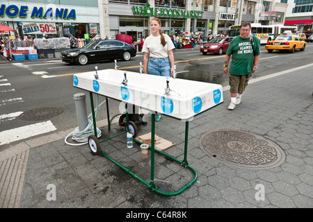 Libera NYC temporaneo di acqua di rubinetto fontanella presidiati da graziosi volontario in quattordicesima strada presso la Union Square Manhattan New York City Foto Stock