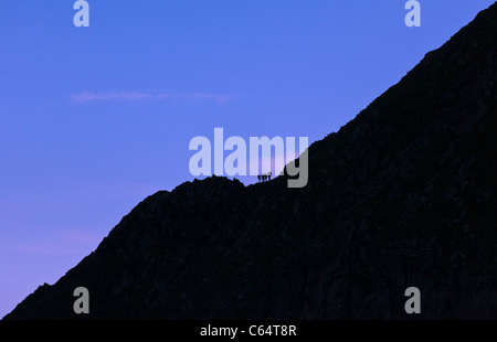 Gli alpinisti stagliano sulla cresta della montagna, fare il bilancio dei loro dintorni. Bordo di estensione, Lake District, UK. Foto Stock