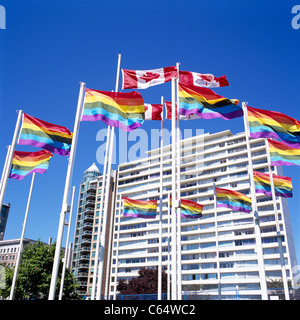 Vancouver, BC, British Columbia, Canada - Gay Pride bandiera arcobaleno e bandiere canadesi soffiando nel vento, West End della città Foto Stock