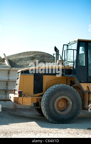 Escavatore close-up e pile di Sfondo sabbia Foto Stock