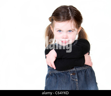 Sassy bambino con le braccia incrociate sul bianco con copyspace. Foto Stock