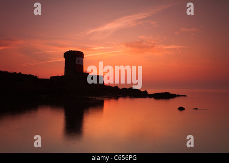 Torre Archirondel, Jersey, all'alba con i colori che riflettono nel mare calmo. Foto Stock