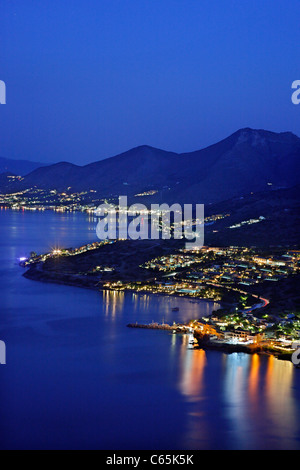 Vista notturna del Golfo di Mirabello, con Plaka in primo piano e Elounda in background Foto Stock