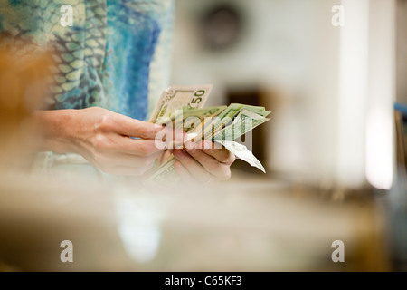Negoziante contando il denaro in negozio Foto Stock