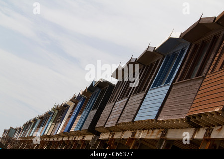 Colorate capanne sulla spiaggia a Frinton-on-Sea, Essex, Regno Unito, un incantevole luogo sul mare perfetto per rilassarsi e godersi le viste costiere Foto Stock