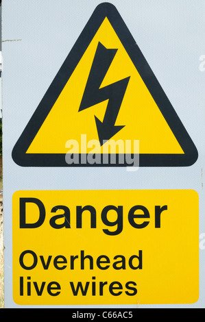 Pericolo cavi aerei sotto tensione segnale di avviso accanto a una linea ferroviaria, Shepreth, Cambridgeshire, England, Regno Unito Foto Stock