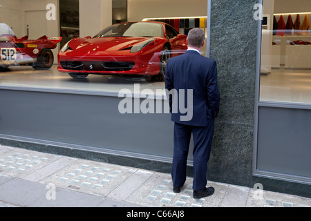 L'uomo guarda in una concessionaria Ferrari a Londra Foto Stock