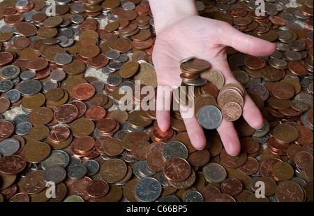 Mano con le monete con sfondo di monete Foto Stock