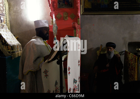 I cristiani ortodossi etiopi pregano all'interno della cappella "Quattro Animali" nel monastero di Deir El-Sultan, che si trova sul tetto della Chiesa del Santo Sepolcro nella città vecchia di Gerusalemme Israele. Foto Stock