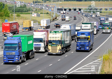 Camion di trasporto carrello quattro corsie tratto di autostrada M25, Essex campagna sorpasso più lento di hgv camion e autocarri del traffico su gradiente England Regno Unito Foto Stock