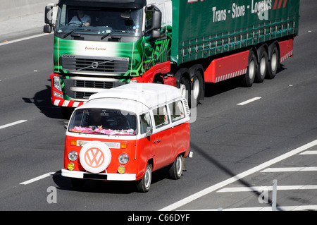 Classico Volkswagen VW Camper sulla autostrada DEL REGNO UNITO (oscurate targa) anteriore montata la ruota di scorta con logo VW England Regno Unito Foto Stock