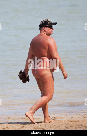 Western uomo a camminare su una spiaggia in Thailandia Foto Stock