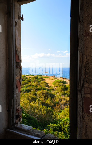 Una vista del costo dalla finestra del faro di Capo Comino, Sardegna, Italia Foto Stock